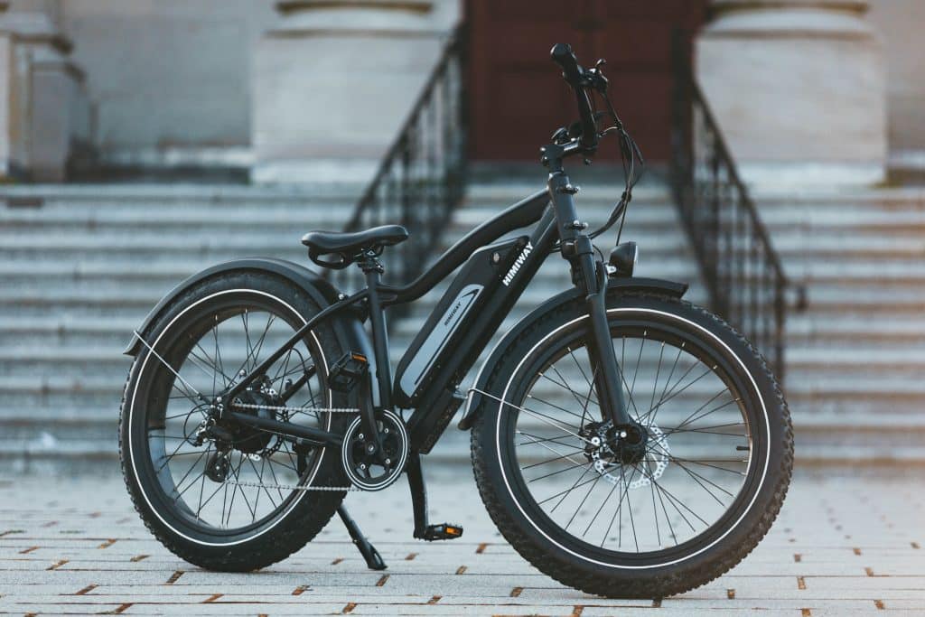 A black Himiway e-bike parked in front of stairs.